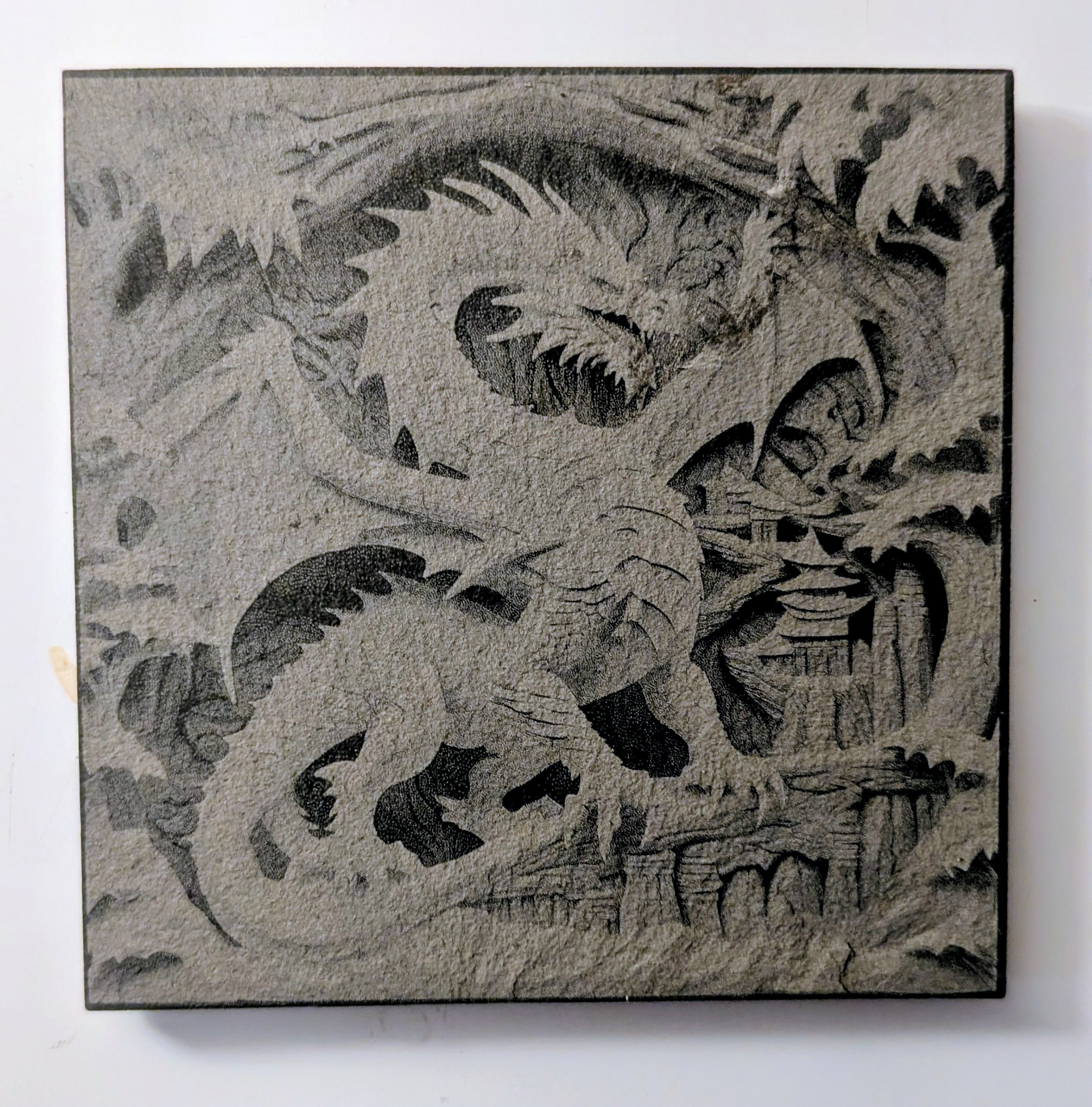 slate coaster with a dragon engraved on it